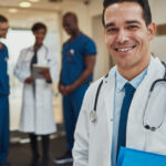 Private hospital for upper endoscopy doctor smiling with other doctors behind him